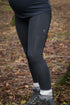 Full length shot of black maternity leggings, worn by woman standing in woodland wearing chunky socks and hiking boots